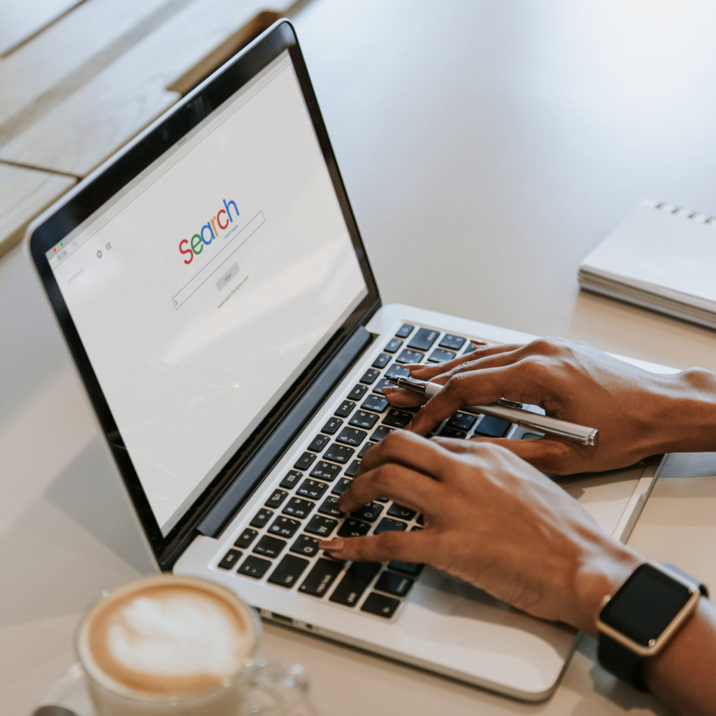 Hände tippen am Laptop mit Suchmaschine