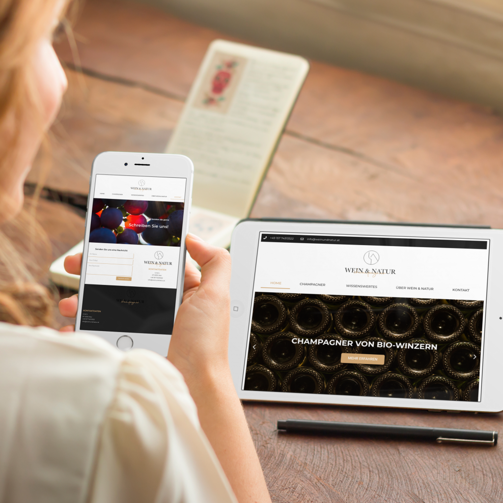 Hand mit Smartphone neben Tablet