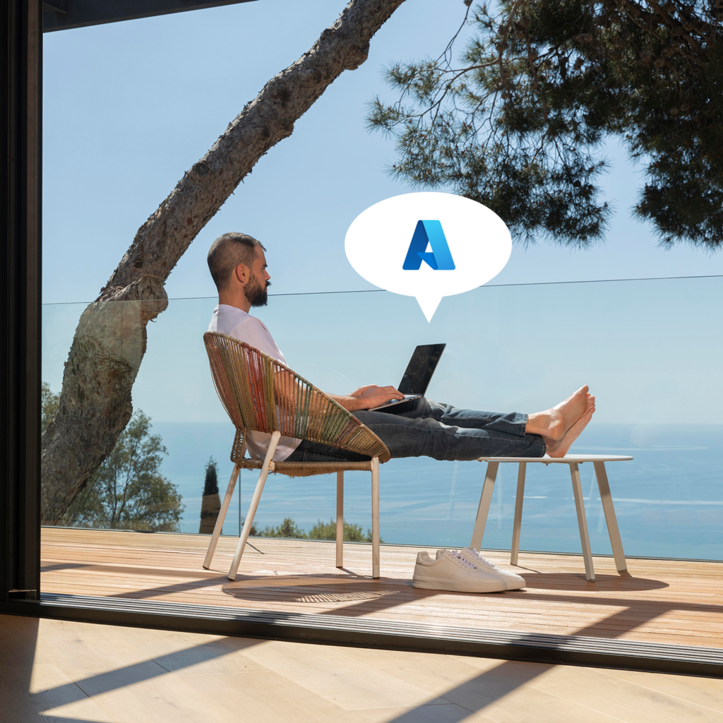 Person mit Laptop auf Terrasse am Meer