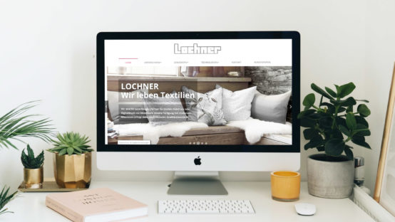 Website auf iMac am Schreibtisch