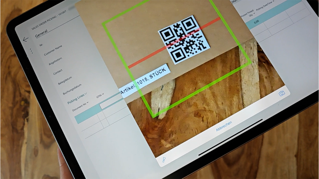 Tablet scannt QR-Code an einem Paket